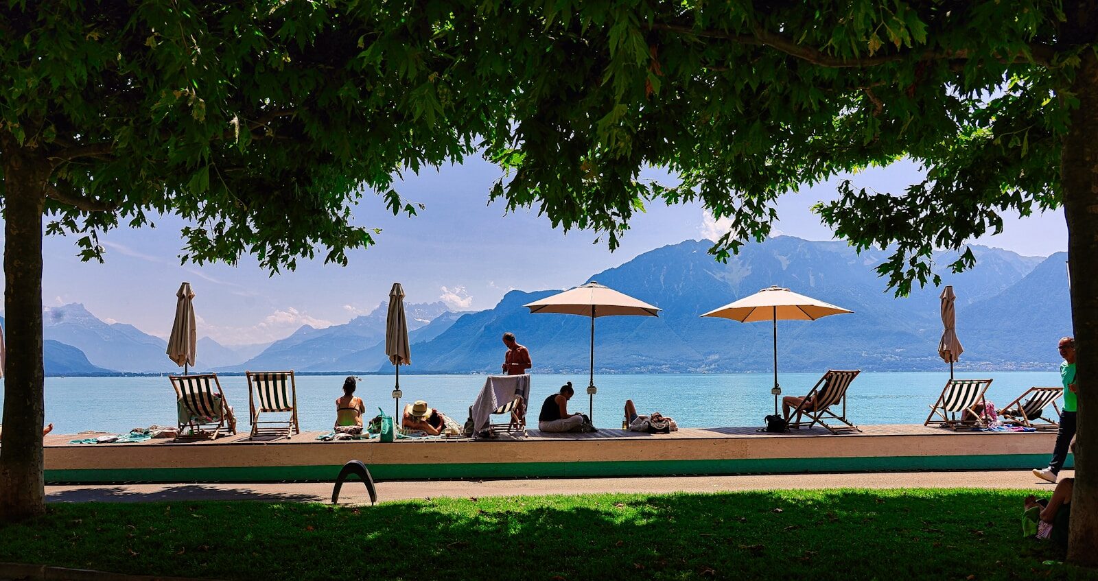 A group of people sitting under umbrellas on a beach