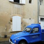 a blue truck parked in front of a building