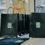 black shopping bags sitting on a table in front of a window